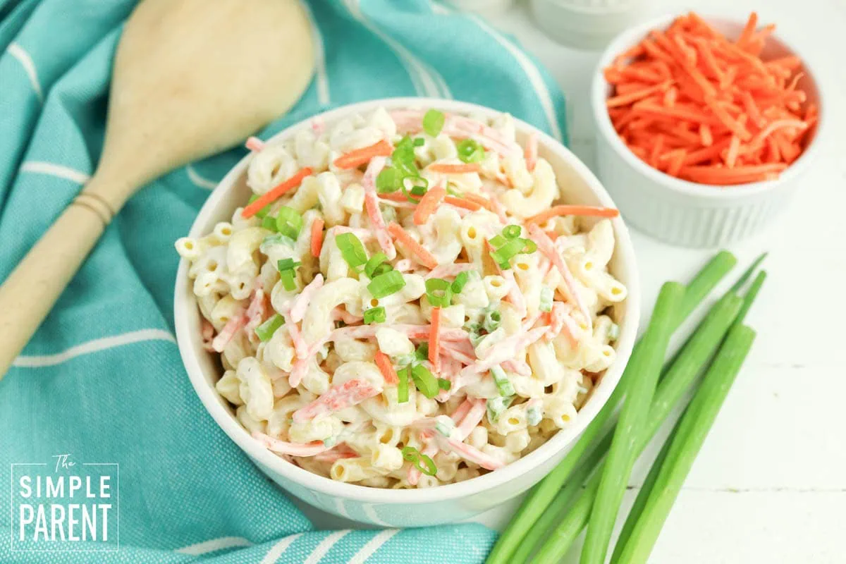 cold macaroni salad recipe in white bowl and wooden serving spoon