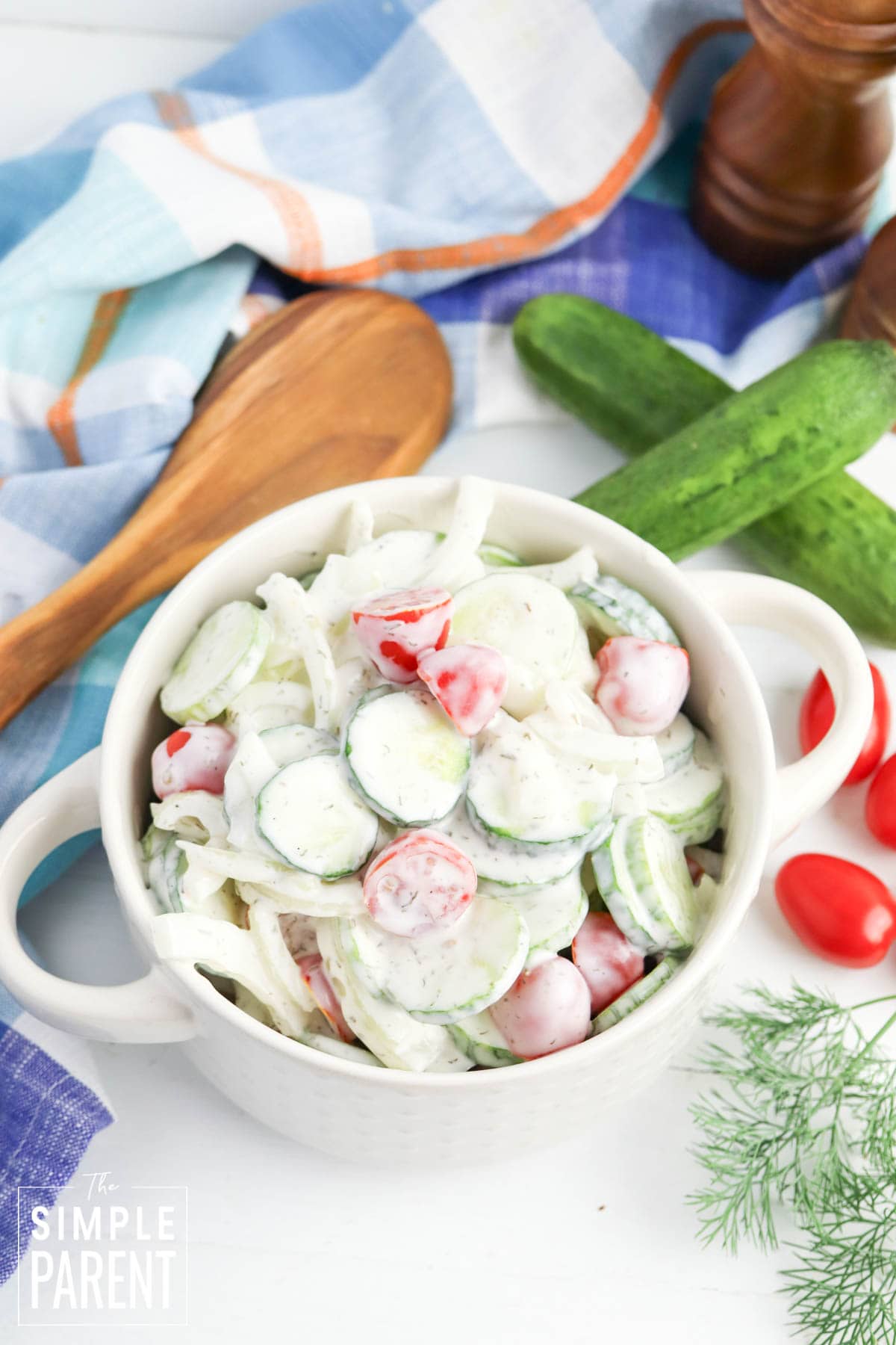 Easy Creamy Cucumber Salad with Tomatoes in white serving bowl