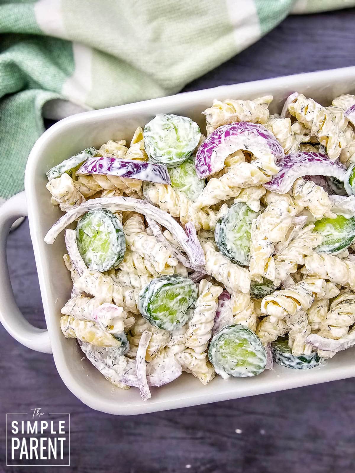 Cucumber Pasta Salad with onions in white serving dish