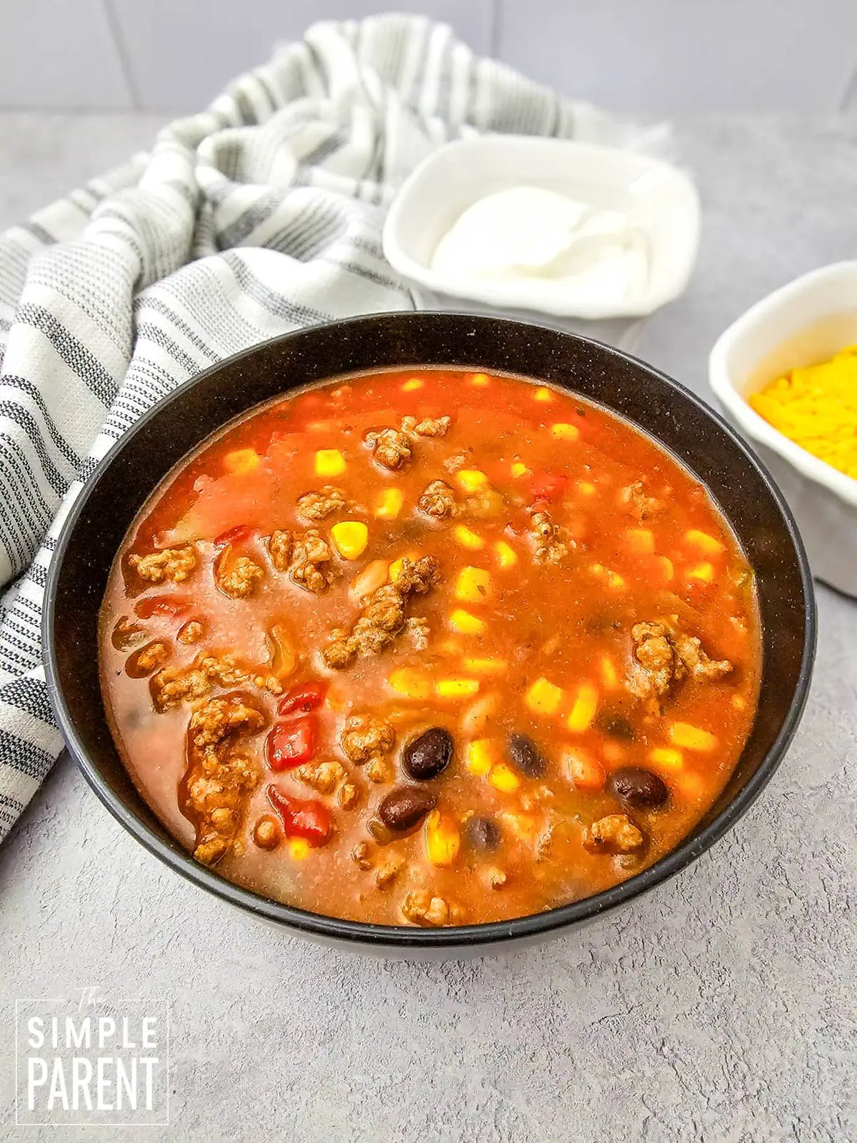 7 Can Taco Soup in black bowl on gray counter top