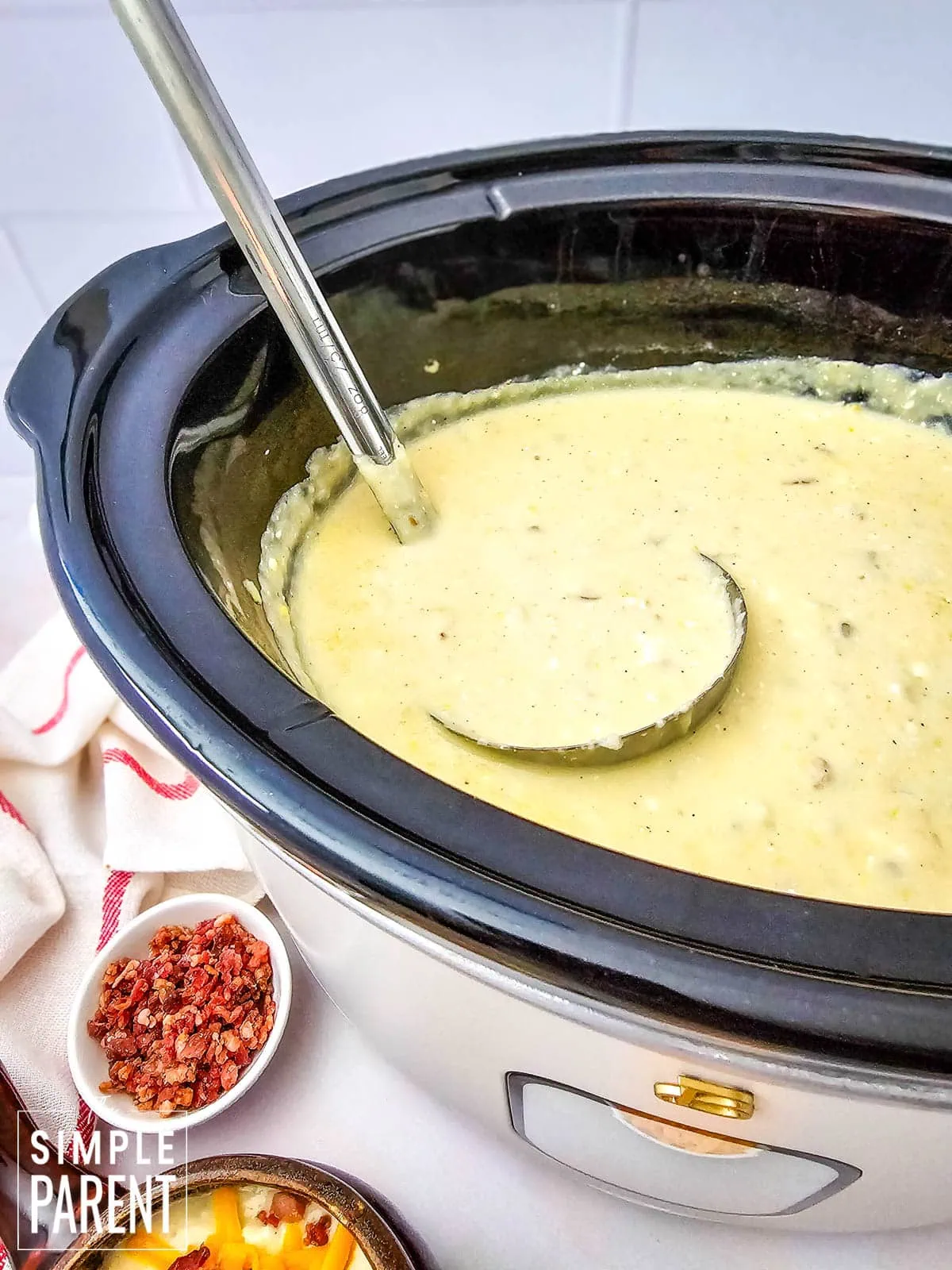 Crockpot baked potato soup with ladle