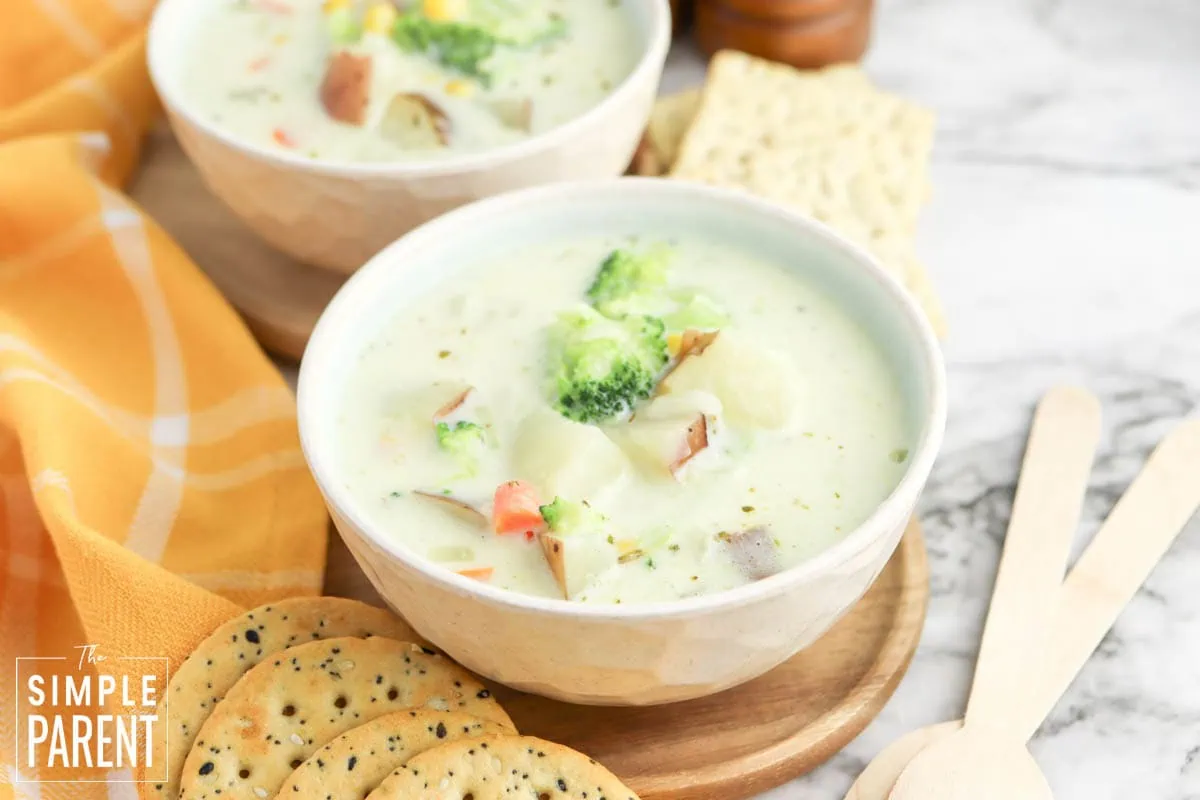 One pot creamy vegetable soup in white bowl with crackers