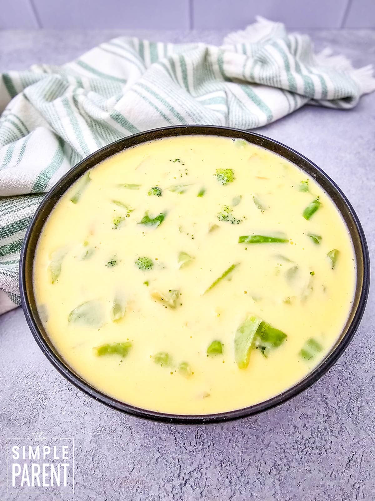 Velveeta Broccoli Cheese Soup in black bowl on gray counter